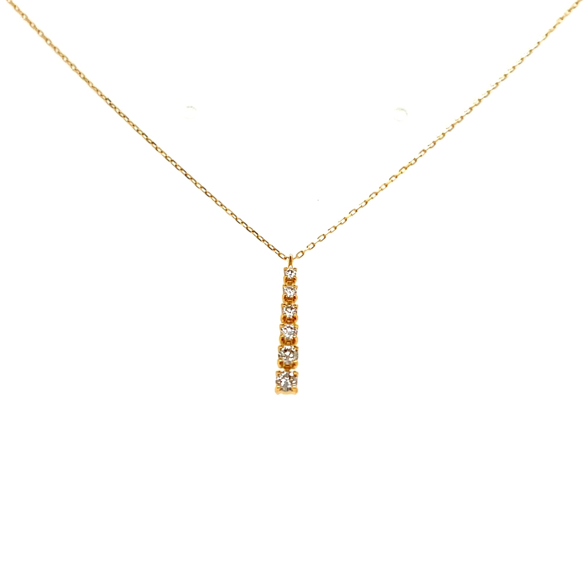 Gold necklace with a small pendant on a white background