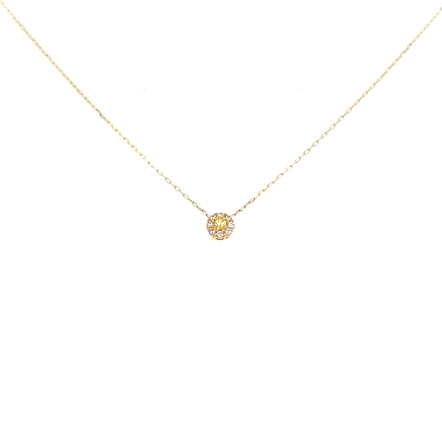 Gold necklace with a small round pendant on a white background