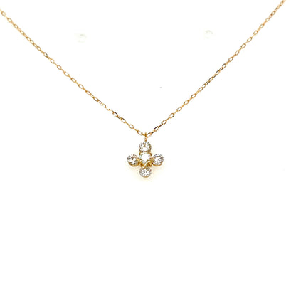 A delicate gold chain necklace with a small four-petal flower pendant set with clear round gemstones, displayed against a solid white background.