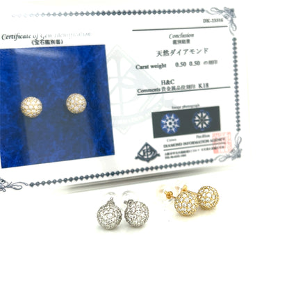 Pair of gold and silver earrings with a certificate on a white background