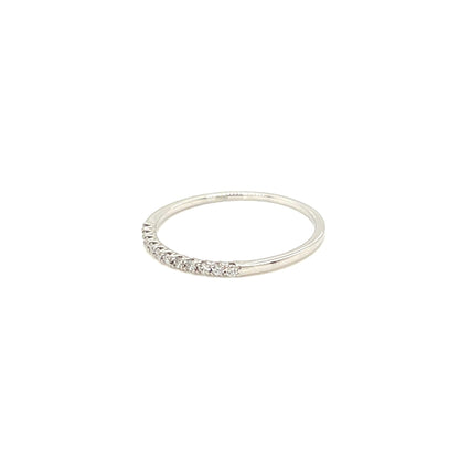 A thin silver band ring featuring a row of small clear stones along the front, photographed against a solid white background.