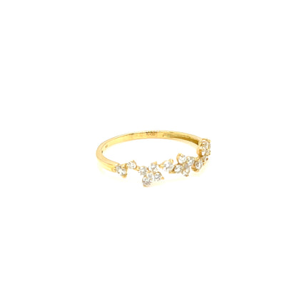 A delicate gold ring featuring a small cluster of clear gemstones in a floral or leaf-like arrangement, set against a solid white background.