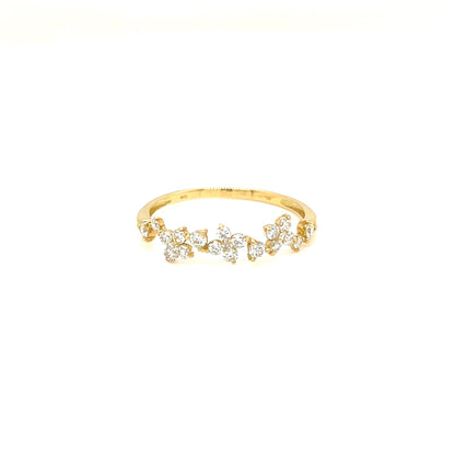 A delicate yellow gold ring featuring a row of small clear gemstones in a floral or leaf-like cluster design, set against a plain white background.