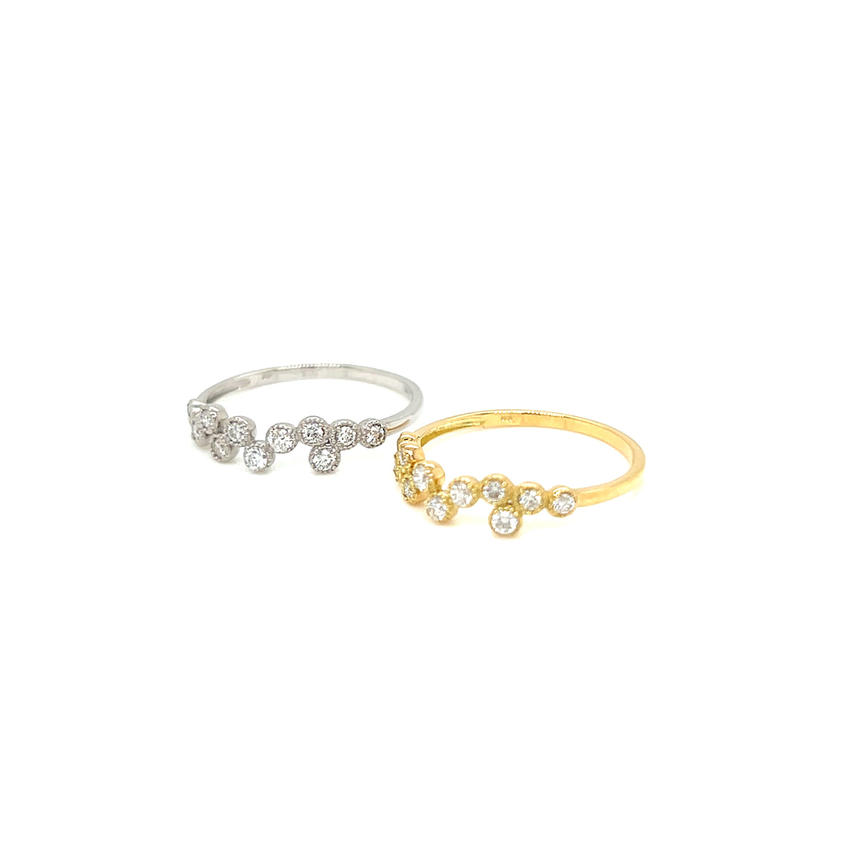 Two delicate flower-shaped rings with small clear gemstones, one in silver-tone metal and one in yellow gold-tone metal, displayed on a clean white background.