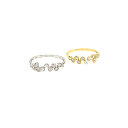 Two delicate flower-shaped rings with small clear stones, one in silver-toned metal and one in yellow gold-toned metal, displayed on a clean white background.