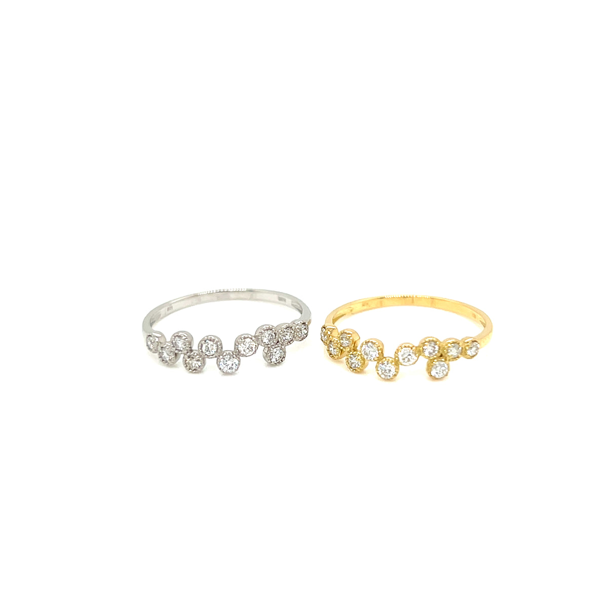 Two delicate cluster rings with small clear gemstones on silver and gold bands, displayed side by side on a plain white background.
