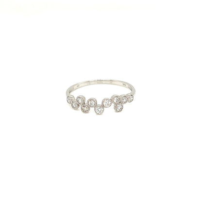A delicate silver band ring featuring a row of small clear round-cut gemstones, photographed against a solid white background.