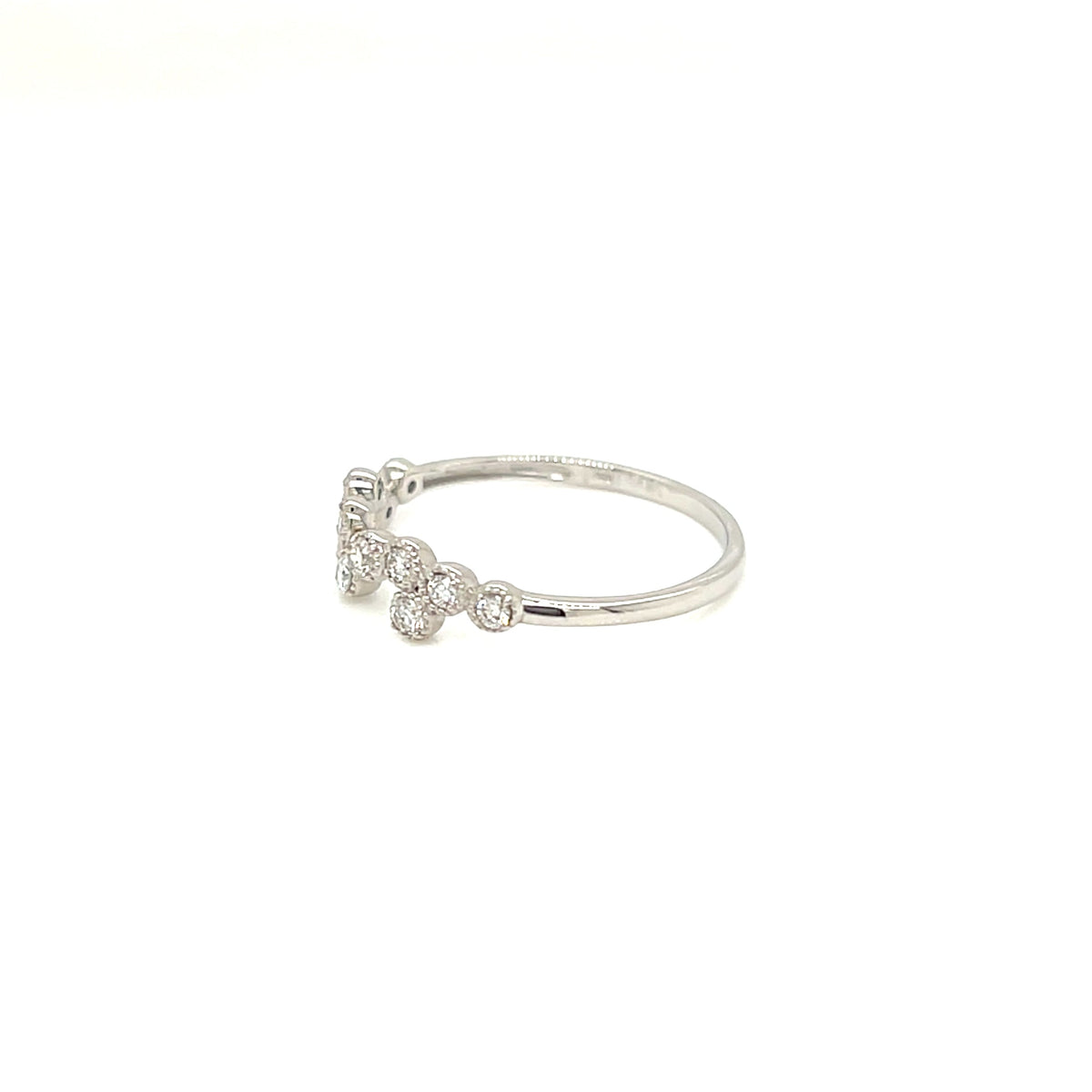 A delicate silver ring featuring a small cluster of clear round-cut gemstones on a plain white background.