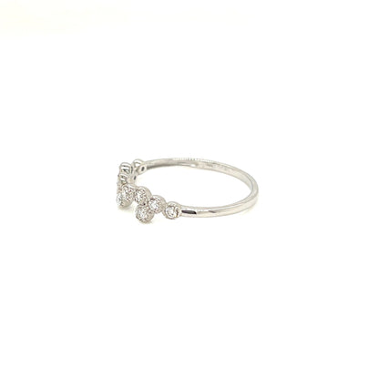 A delicate silver ring featuring a small cluster of clear round-cut gemstones on a plain white background.