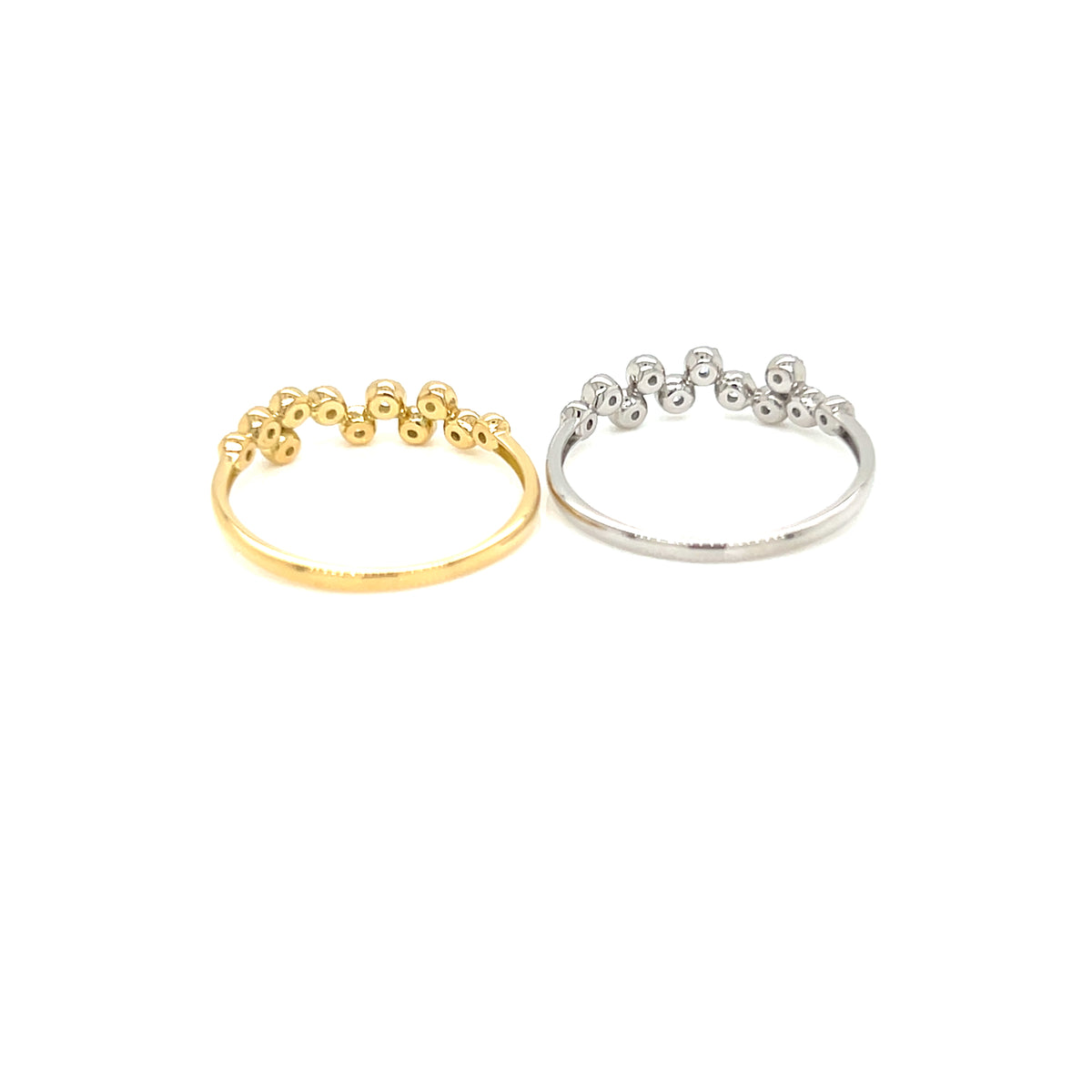 Two delicate open band rings with small bead clusters along the top, shown side by side on a plain white background. One ring is yellow gold and the other is silver.