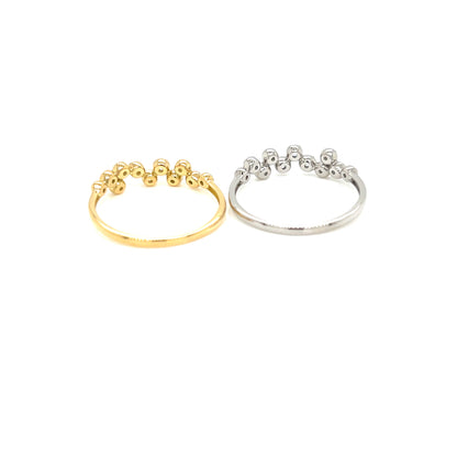 Two delicate open band rings with small bead clusters along the top, shown side by side on a plain white background. One ring is yellow gold and the other is silver.