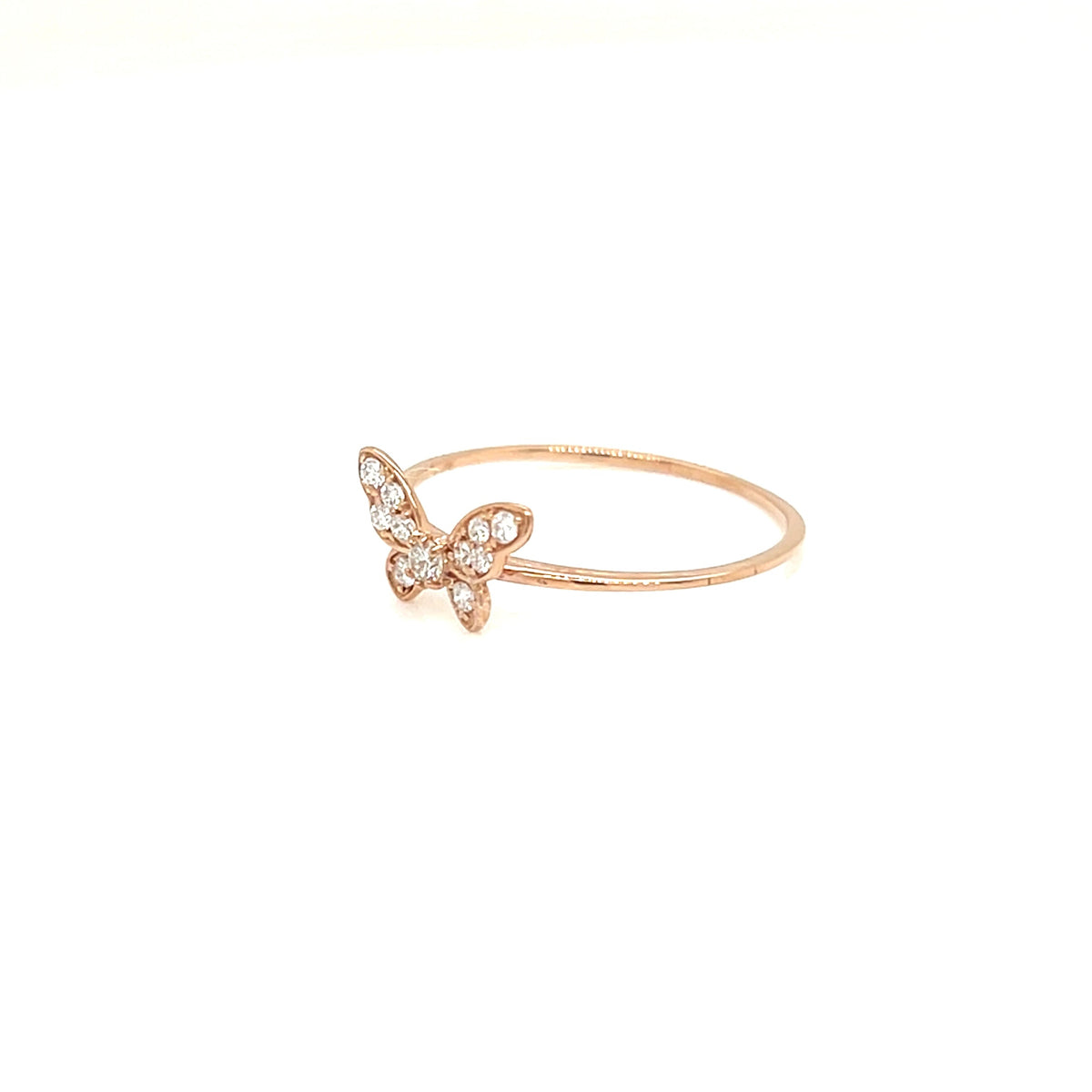 A delicate rose gold ring featuring a small butterfly charm adorned with tiny clear crystals, set against a solid white background.