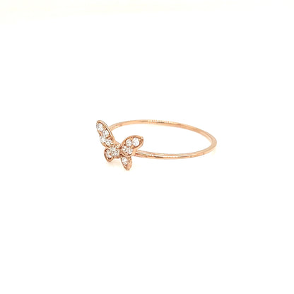 A delicate rose gold ring featuring a small butterfly charm adorned with tiny clear crystals, set against a solid white background.