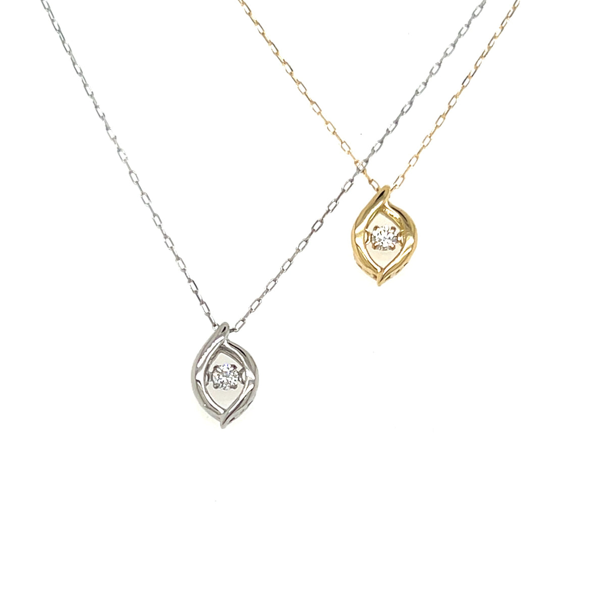 Two delicate pendant necklaces on a plain white background, one in silver-tone metal and one in yellow-gold metal, each featuring a small round clear gemstone in an open teardrop-shaped pendant.
