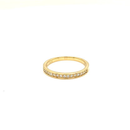 A thin yellow gold eternity ring with a row of small clear stones set along the band, shown against a plain white background.