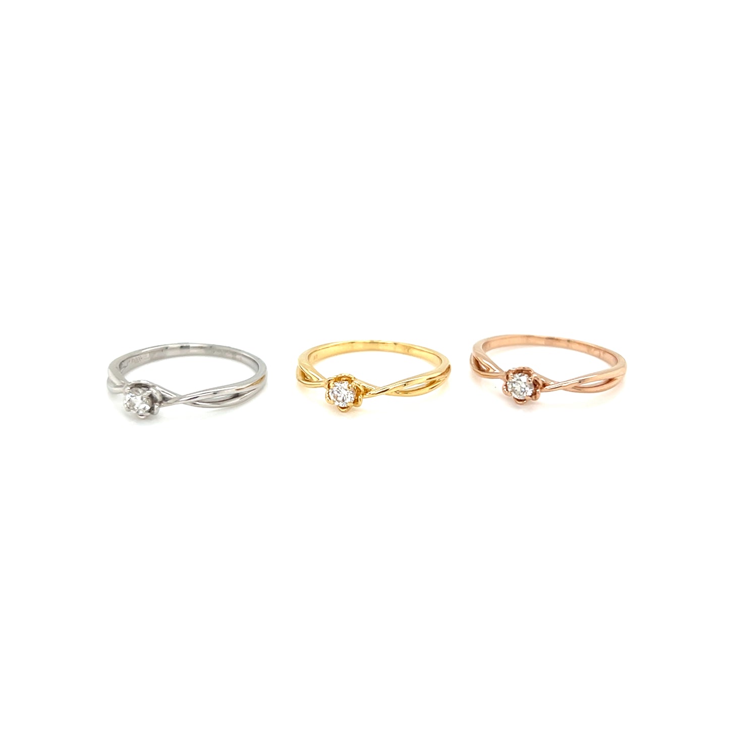 Three rings in white, gold, and rose gold on a white background