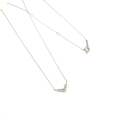 Silver necklace with a v shape pendant on a white background
