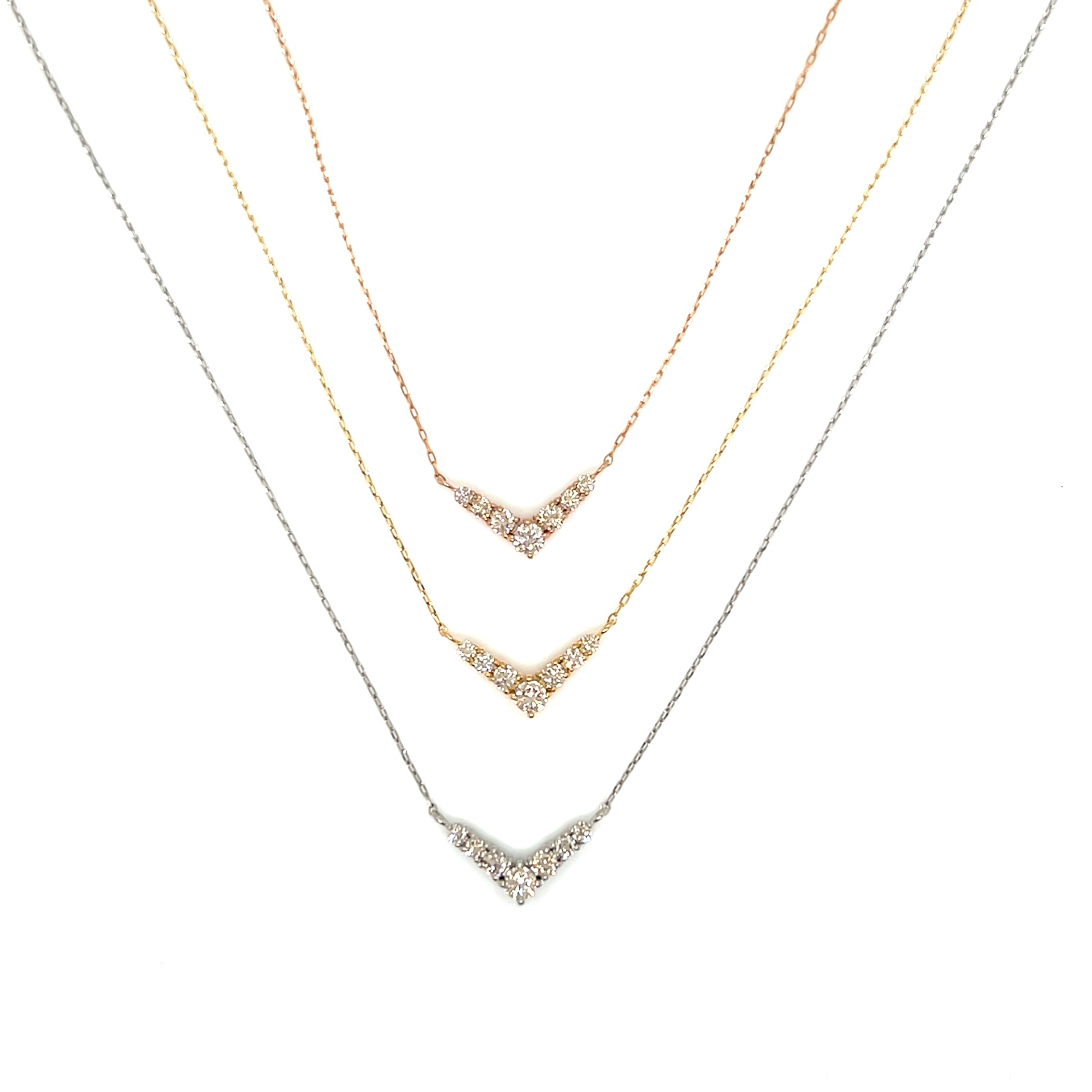 Three gold necklaces with diamond accents on a white background