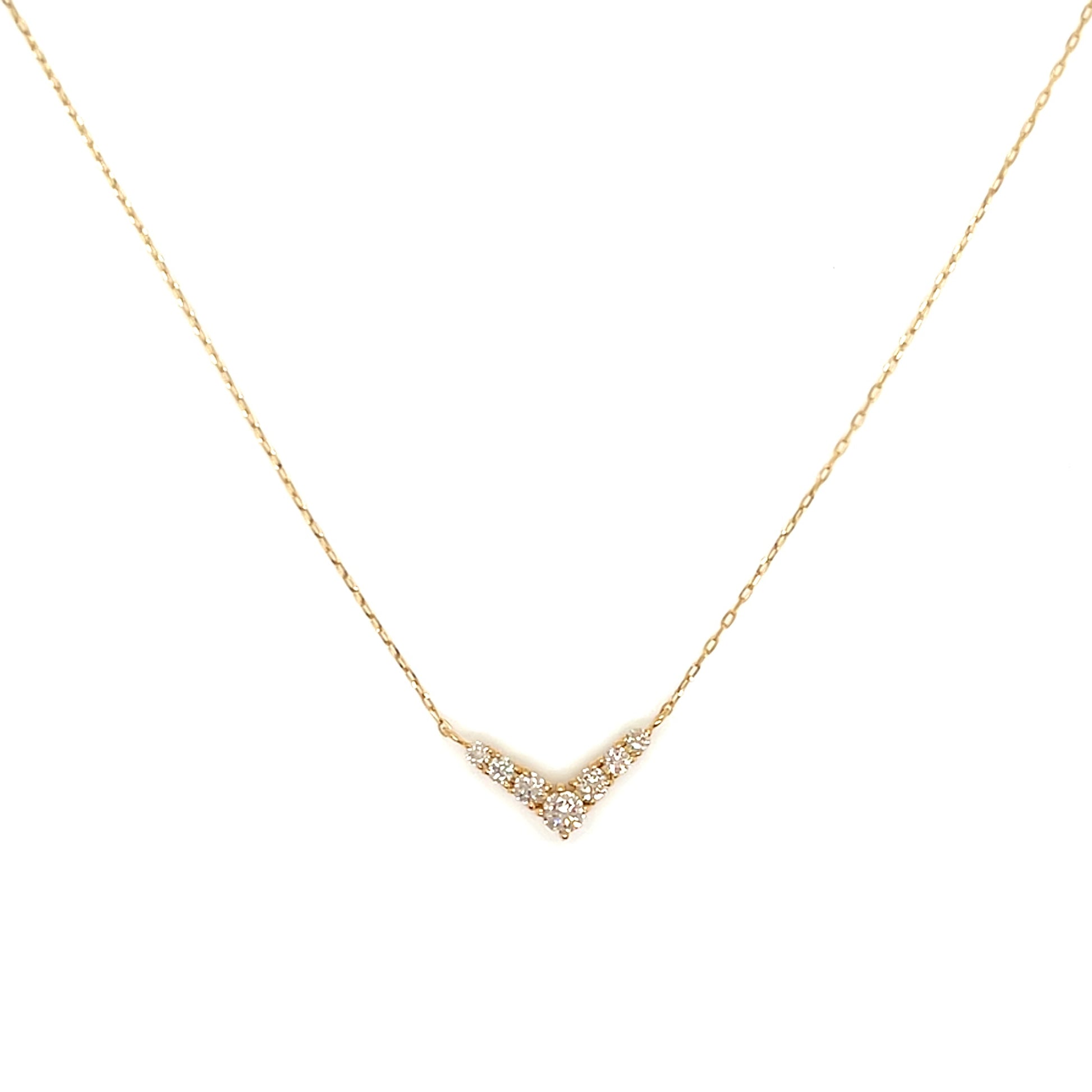 Gold necklace with a small diamond pendant on a white background