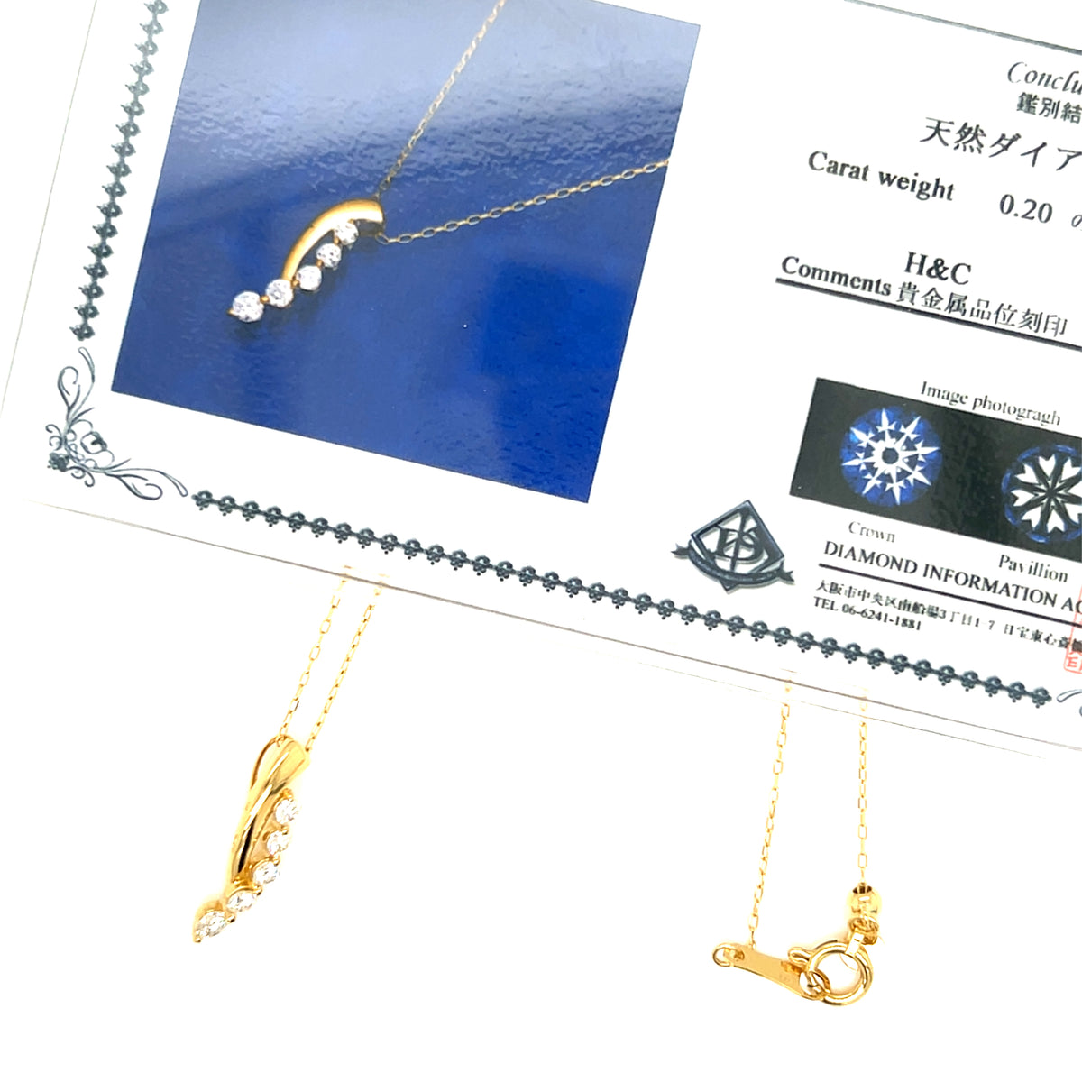 Gold diamond necklace with a curved marquise-cut diamond pendant and a lobster clasp, displayed alongside its Japanese authenticity certificate from Crown Pavilion.
