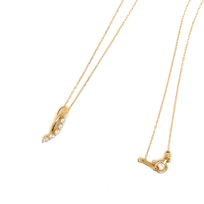 A gold necklace with a delicate chain, featuring a curved pendant adorned with small clear stones on one side and a toggle clasp on the other, displayed on a clean white background.