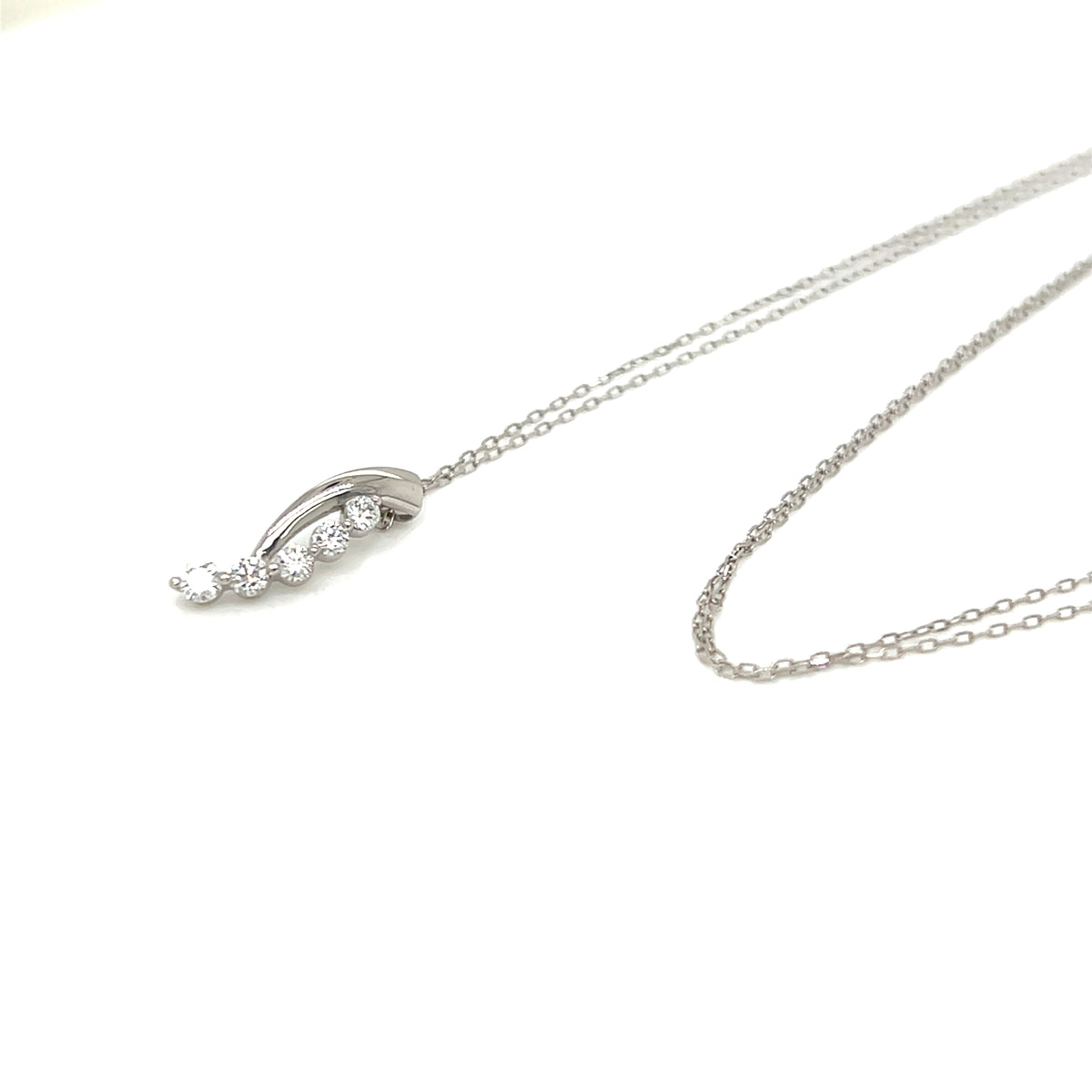 A silver-toned necklace with a delicate chain and a curved pendant featuring small clear gemstones, displayed on a clean white background.