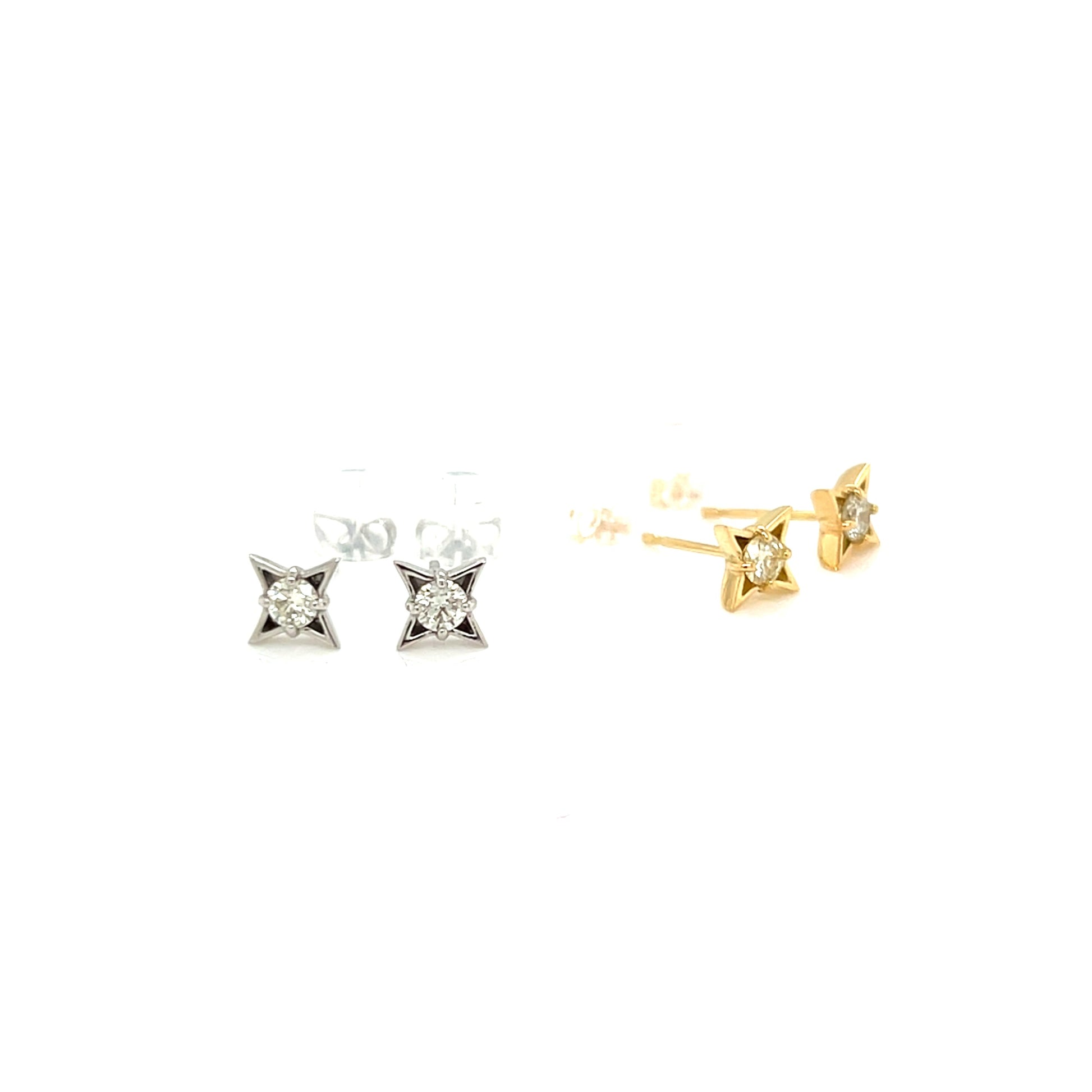 Pair of diamond stud earrings in gold and silver on a white background