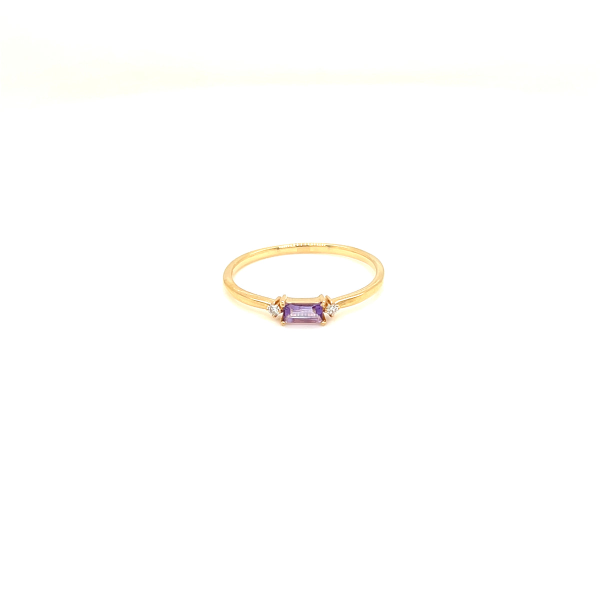 A delicate yellow gold ring featuring a small rectangular purple amethyst gemstone in a bezel setting, flanked by tiny clear accent stones, shown on a plain white background.