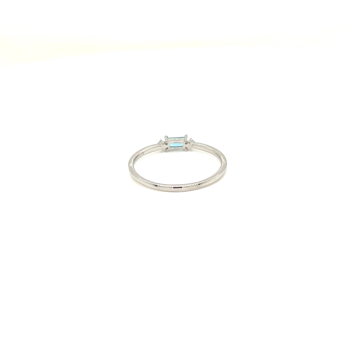 A silver ring featuring a small rectangular light blue gemstone in a bezel setting, centered on a plain white background.