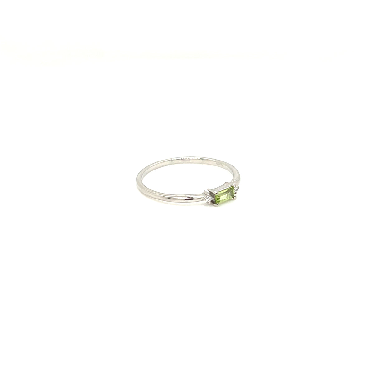 A silver ring featuring a small rectangular green peridot gemstone in a prong setting, shown against a plain white background.