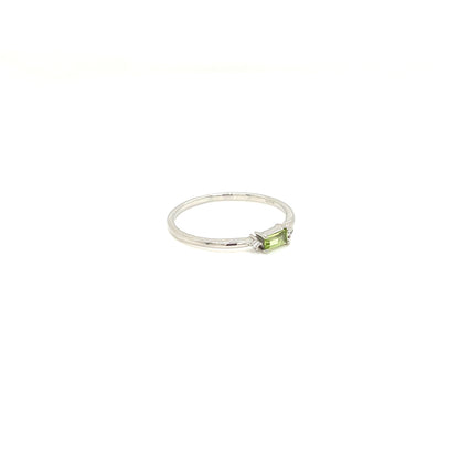A silver ring featuring a small rectangular green peridot gemstone in a prong setting, shown against a plain white background.