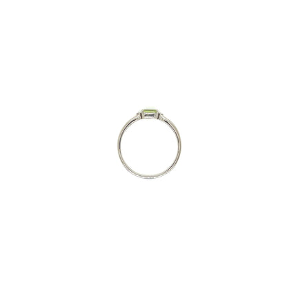 A silver ring featuring a small rectangular green peridot gemstone in a bezel setting, centered on a plain white background.