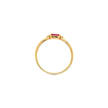 A gold ring with a small rectangular pink gemstone in a bezel setting, centered on a plain white background.