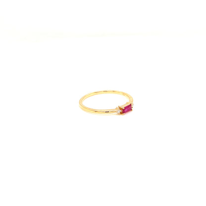 A delicate yellow gold ring featuring a small rectangular pink gemstone in a prong setting, photographed against a solid white background.