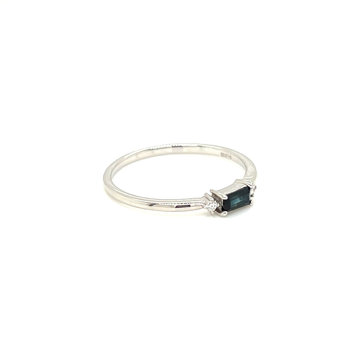 A delicate silver ring featuring a small rectangular dark green gemstone, photographed on a seamless white background.