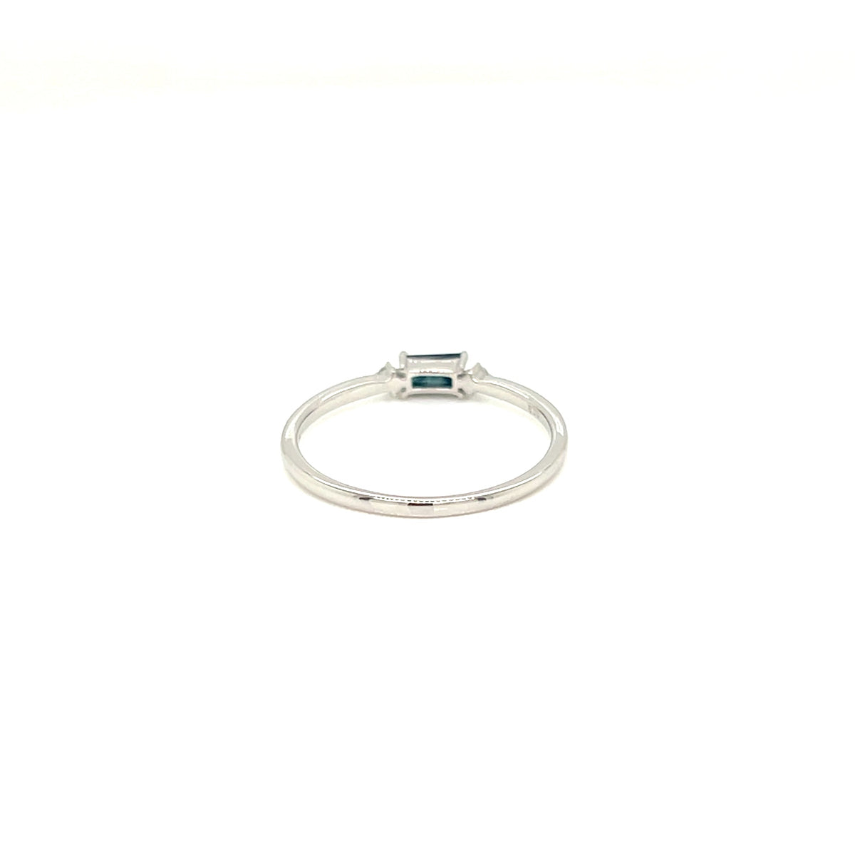 A silver ring featuring a small rectangular emerald-cut blue gemstone in a bezel setting, shown against a plain white background.