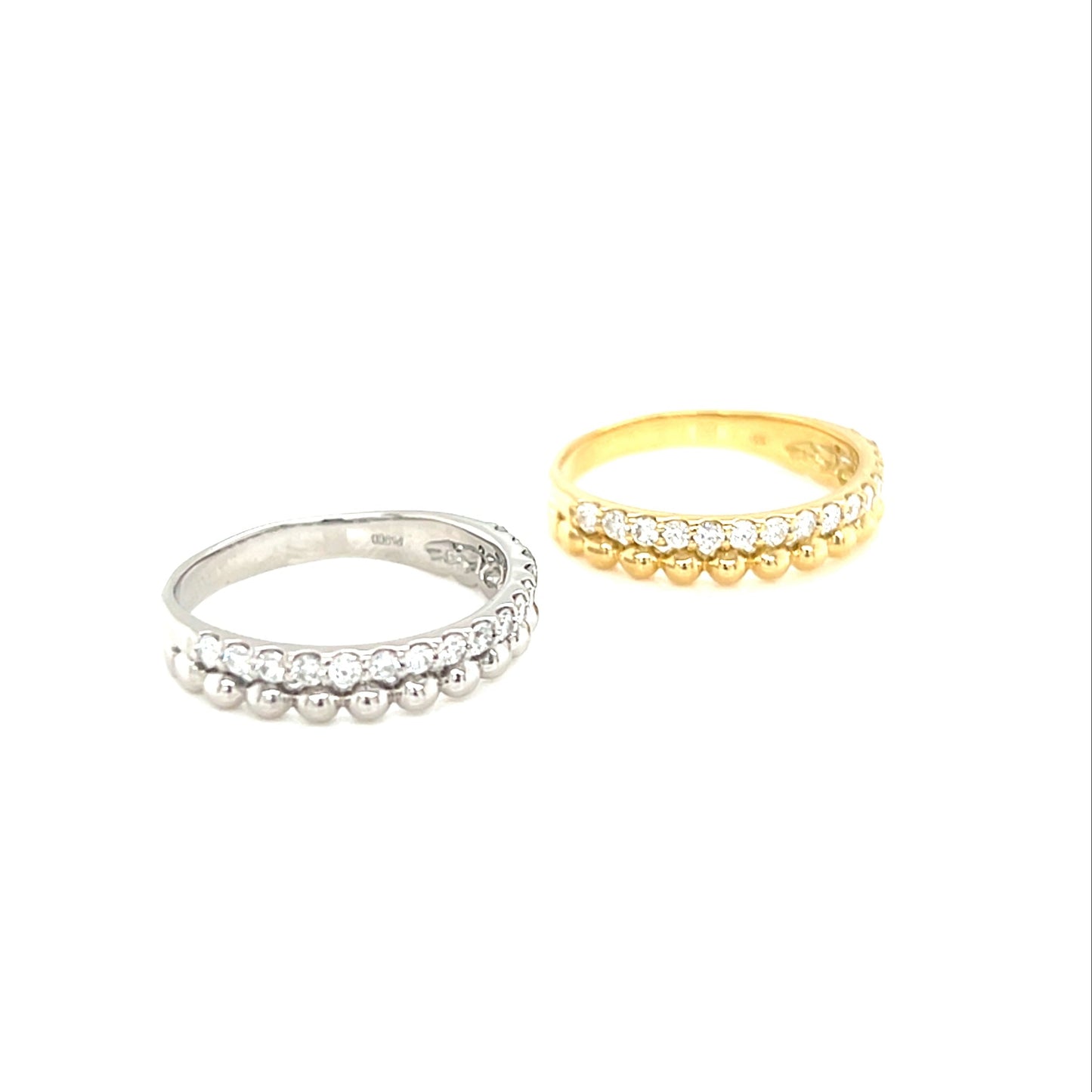Two  diamond rings with beads, one platinum and one gold, on a white background