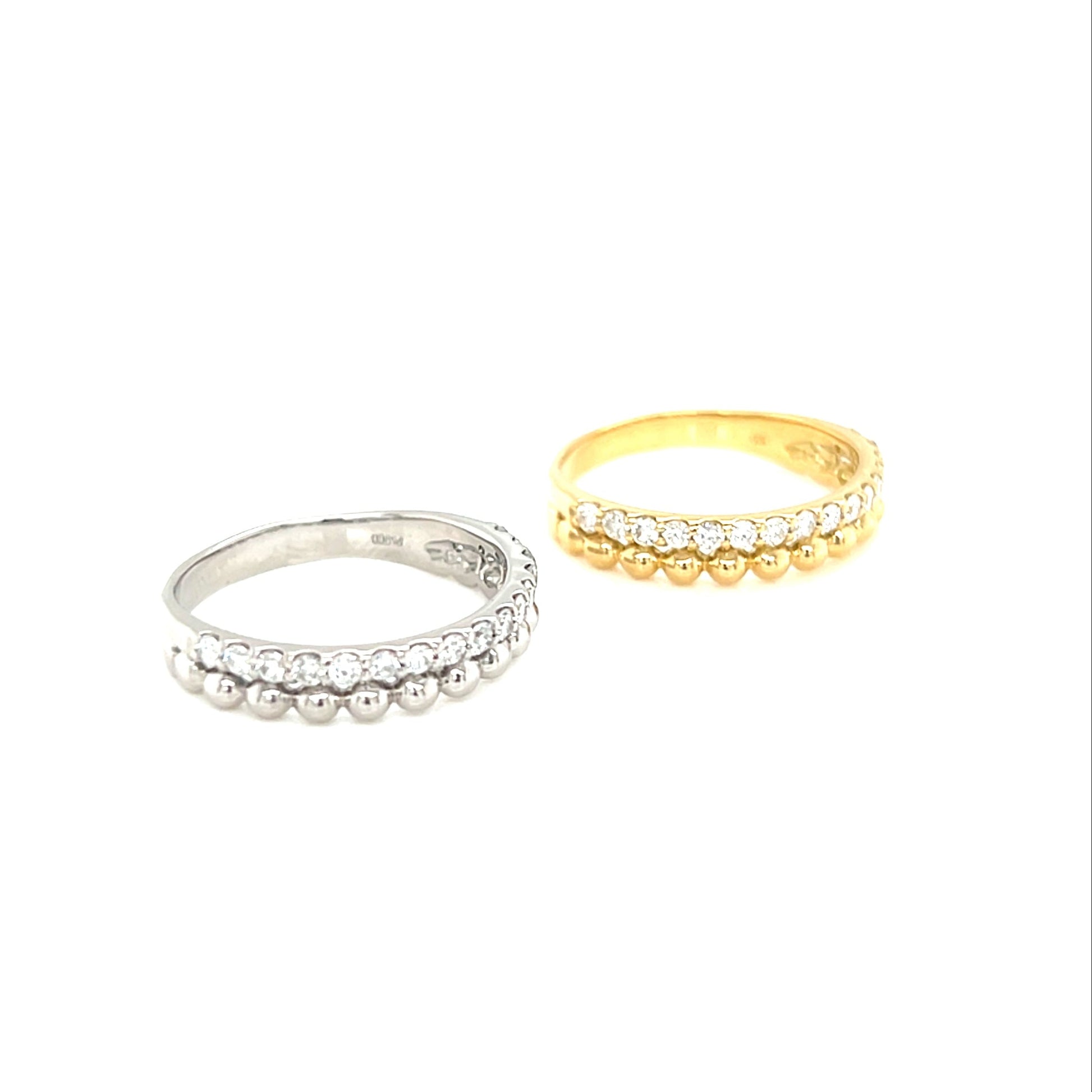 Two  diamond rings with beads, one platinum and one gold, on a white background