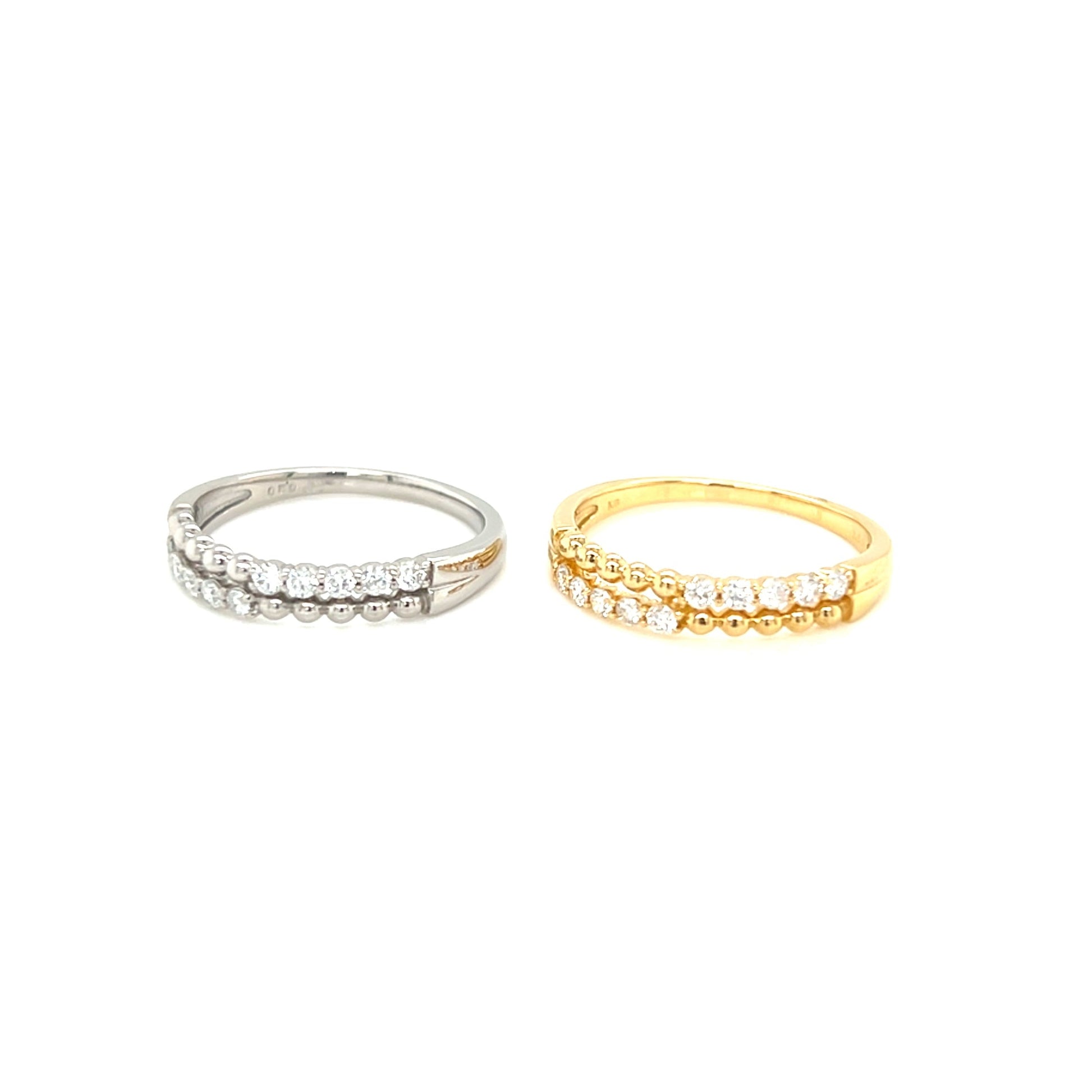 Two diamond rings, one silver and one gold, on a white background