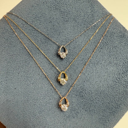 Gold necklace with three waterdrop-shaped pendants on a gray surface