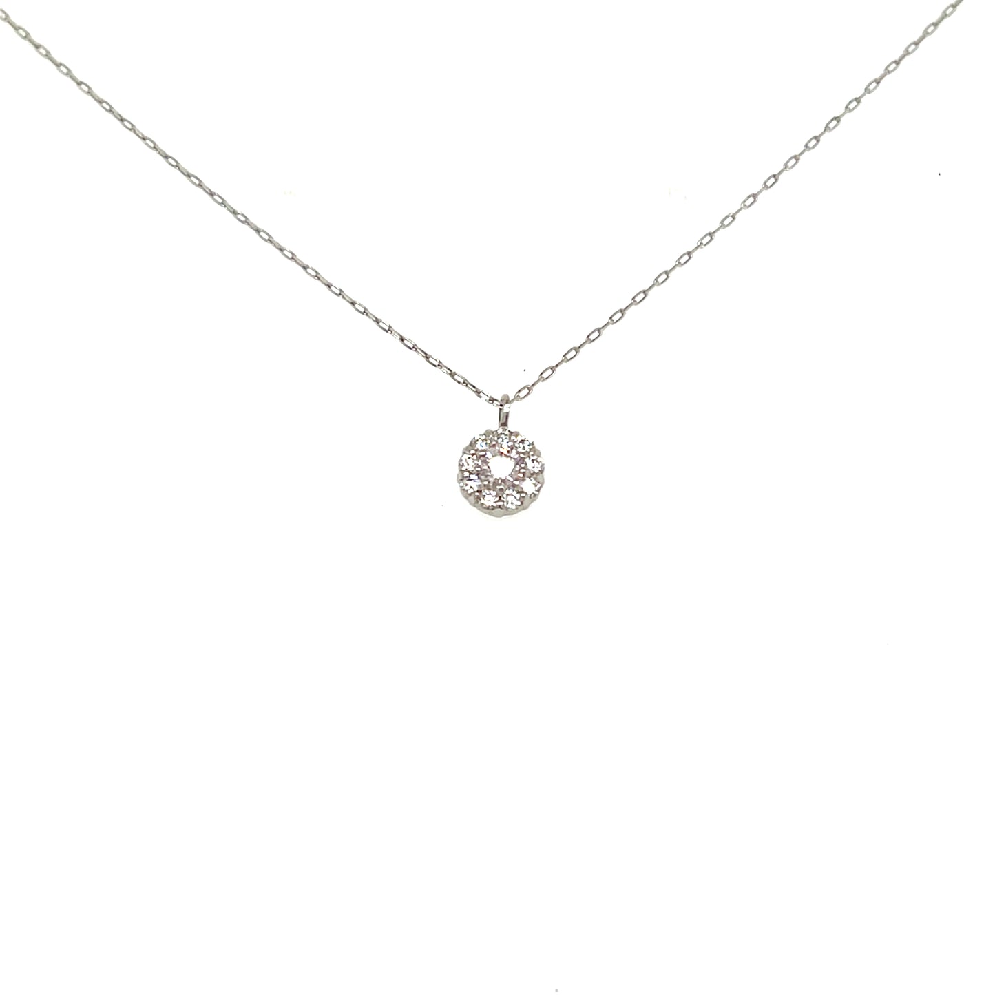 A delicate silver chain necklace with a small circular pendant set with clear stones, displayed against a solid white background.