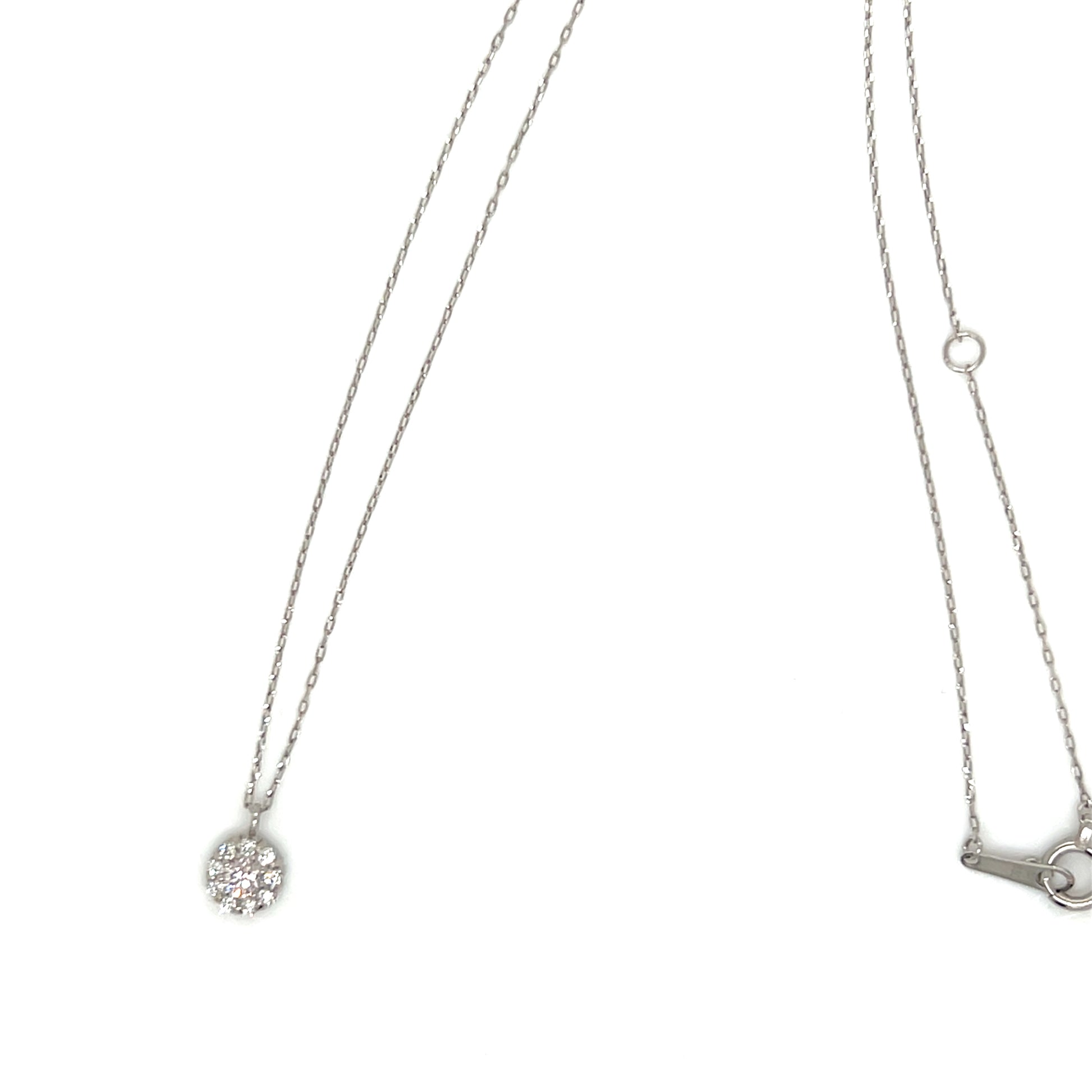 A silver-toned necklace with a delicate chain, featuring a small round pendant paved with clear crystals on the left and a small key-shaped charm on the right, shown against a plain white background.