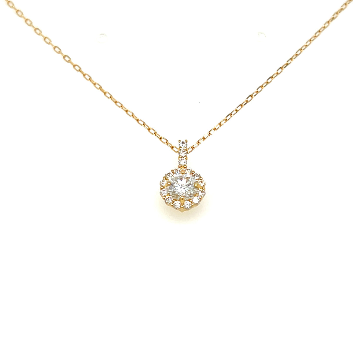 A delicate yellow gold chain necklace with a round halo pendant set with clear gemstones, displayed on a clean white background.