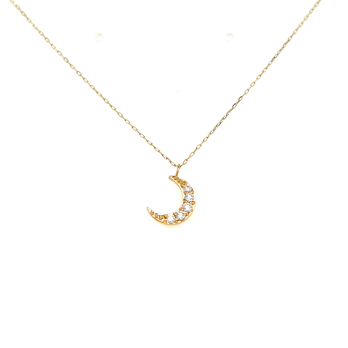 A delicate gold chain necklace with a crescent moon pendant adorned with small clear stones, displayed against a solid white background.