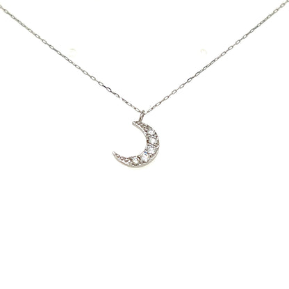 A silver crescent moon pendant necklace adorned with small clear stones, suspended from a delicate silver chain against a plain white background.