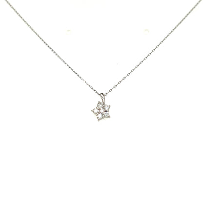 A delicate silver chain necklace with a small pendant featuring tiny clear gemstones, displayed against a solid white background.