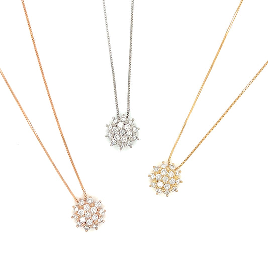 Three snowflake-shaped pendants on necklaces in rose gold, silver, and gold on a white background.