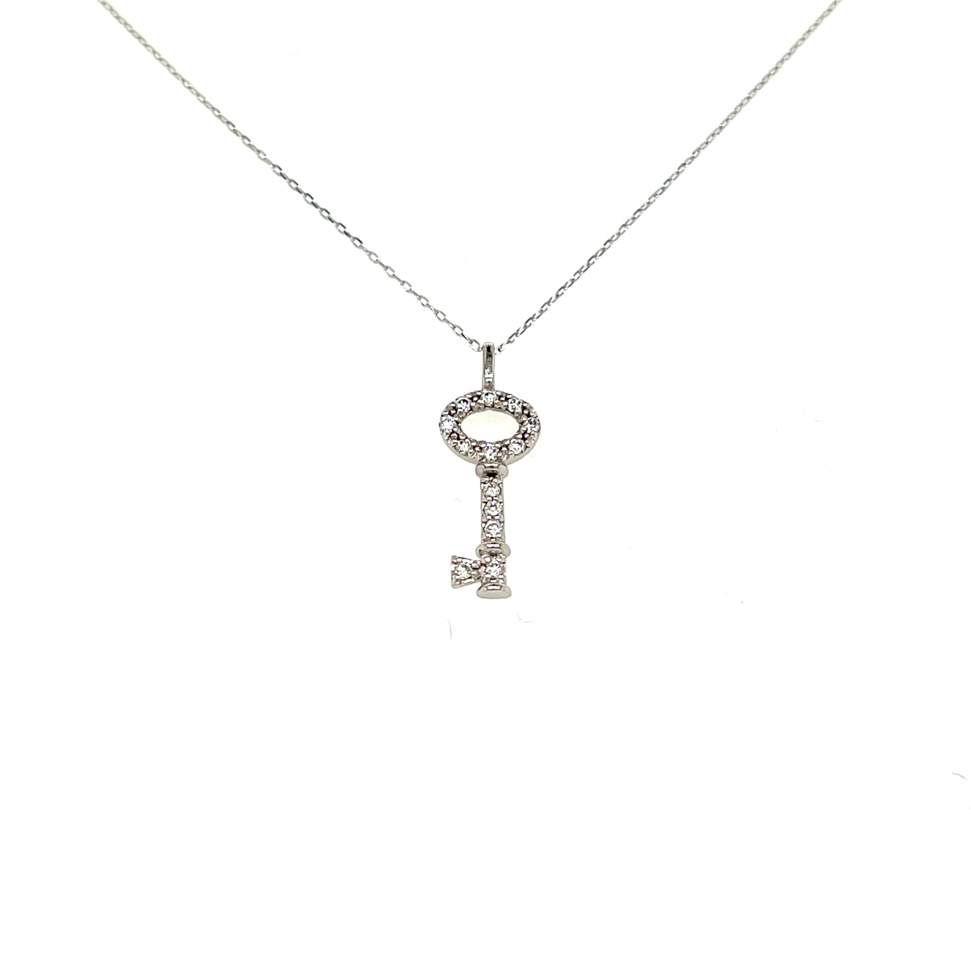 A silver key-shaped pendant necklace adorned with small clear stones, suspended from a delicate silver chain against a plain white background.