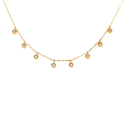 Gold necklace with small dangle diamonds on a white background