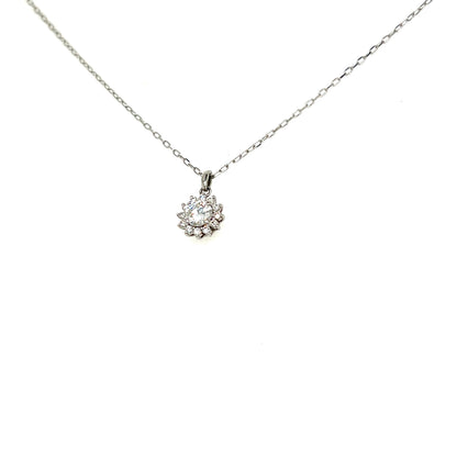 A delicate silver chain necklace with a small floral cluster pendant featuring a clear central gemstone, shown against a plain white background.